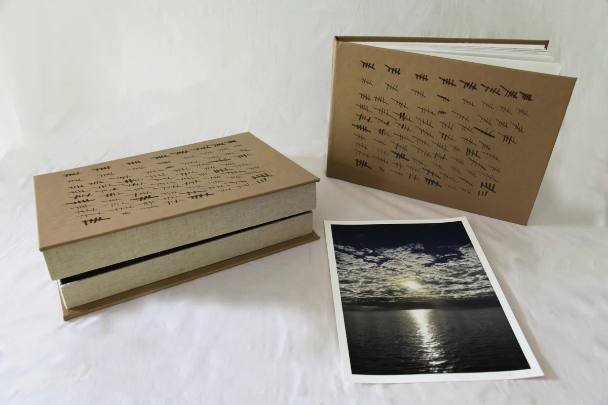 398 Days Artist Book, limited edition of 10: a leather-bound book and clamshell box tallied in burned hash marks, shown with one of the artist prints from the series