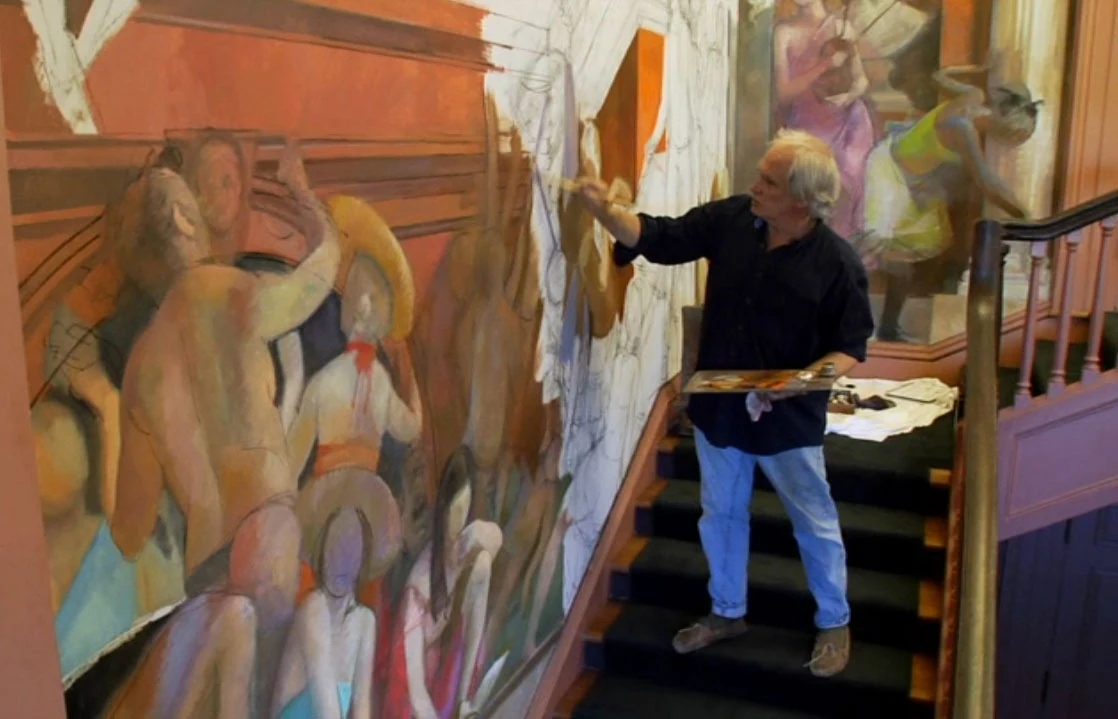Lincoln Perry at work on one of his murals, palette in hand, on the stairs of a stairwell installation