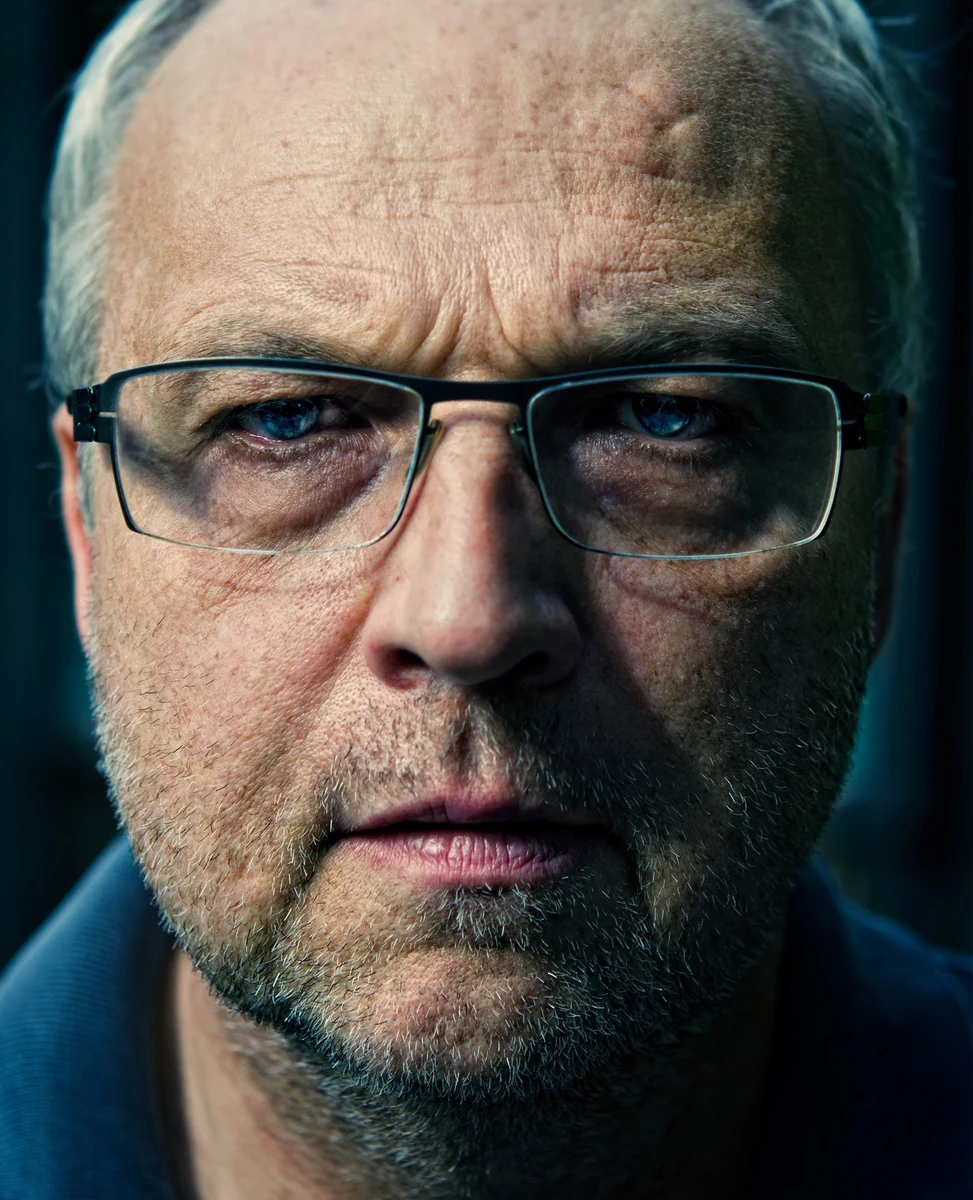 Rainer Lagemann, close head-and-shoulders portrait in glasses against a dark background