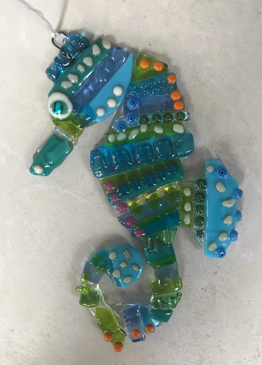 Fused glass seahorse wall hanging in turquoise, blue and green with orange and white accents